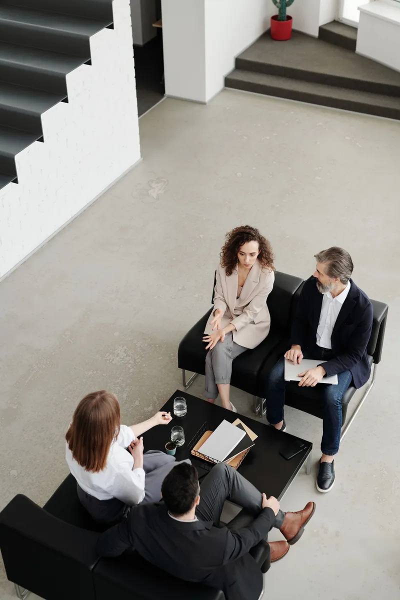 Four colleagues seated around a low table, seen from above