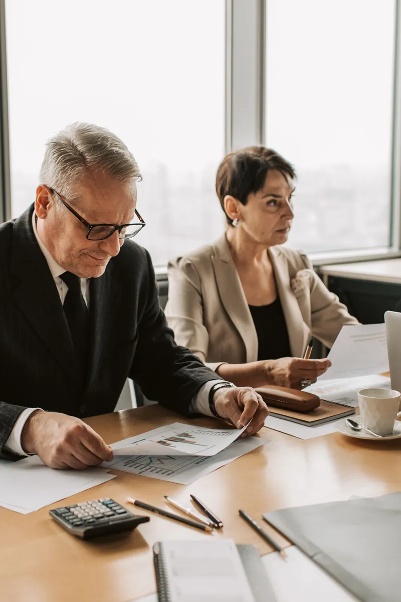Two colleagues reviewing documents at a meeting table